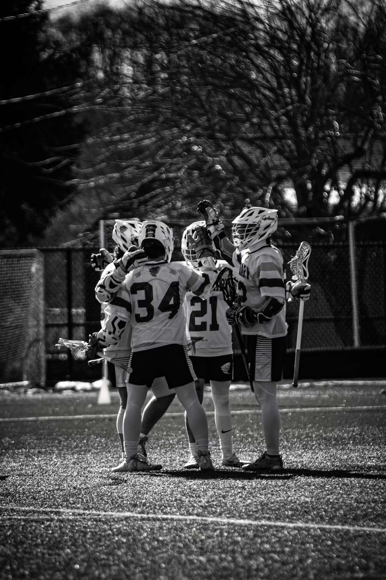 Teammates celebrating a goal, black and white